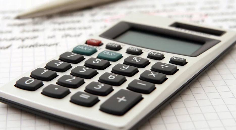 calculadora sobre uma folha com anotações para calcular tarifas bancárias